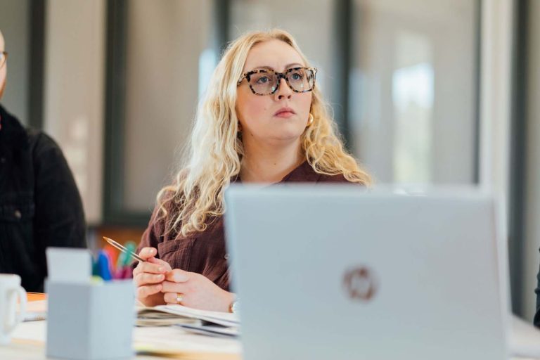 Woman listening in front of laptop